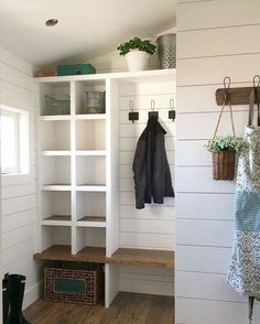 the inside of a room with white walls and wood flooring, two open shelvings