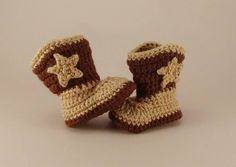 two crocheted brown and white baby booties with star on the top, sitting next to each other