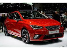 a red car is on display at an auto show