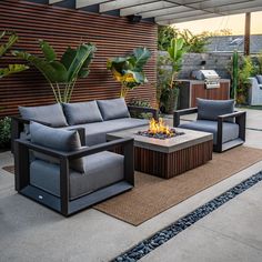 an outdoor living area with couches and fire pit