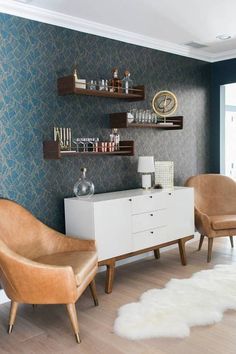 a living room with two chairs and shelves on the wall next to a white rug