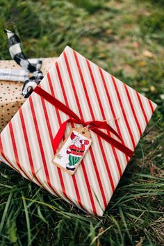 an open gift box wrapped in red and white striped paper with a tag on it