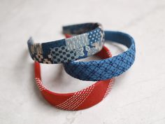 three bracelets with red, white and blue designs on them sitting next to each other