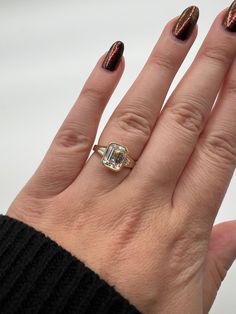 a woman's hand with a ring on it and a diamond in the middle