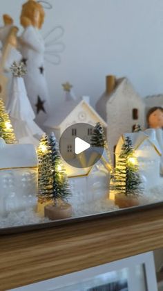 a christmas scene with angel figurines on top of a mantle and trees in the foreground