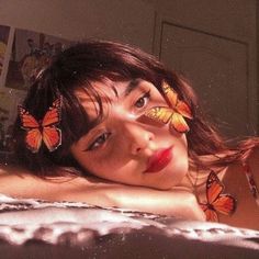 a woman laying on top of a bed covered in butterflies