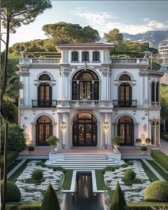 this is an image of a large house in the middle of a garden area with trees and bushes around it