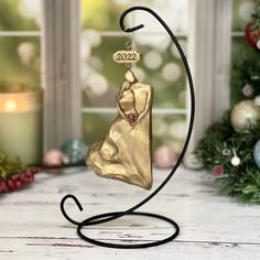 a gold christmas ornament on a black stand