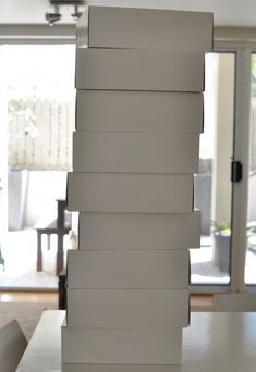 a stack of white boxes sitting on top of a table in front of a sliding glass door