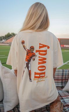 Say HOWDY! from football country in this off-white tee complete with a vintage inspired illustration of a quarterback mid pass! We love the red and yellow colorway of this design. 


Haley is 5'6" and is wearing size medium

Maggie is 5'4" and is wearing an XL for an oversized look


sizing guide: 


fits true to size - size up for an oversized fit

medium measurements: 41" bust and 28.5" length

100% cotton


WE ONLY OFFER STORE CREDIT FOR RETURNS! Feel free to email us at orders@shopriffraf Vintage College Football Shirts, Country T Shirt Designs, Game Day Shirts Football, Sorority Apparel Ideas, College Shirt Ideas, School Shirt Ideas, Bulldog Football, Track Shirt, Off White Tees