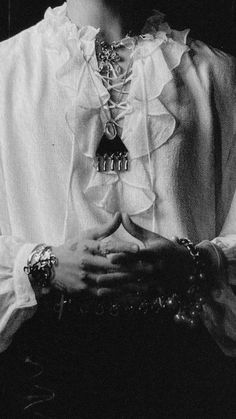 a black and white photo of a woman with her hands clasped in front of her chest