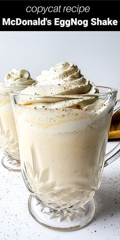 two glasses filled with whipped cream on top of a table