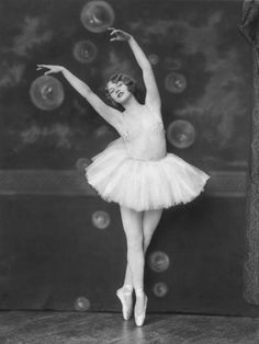 an old black and white photo of a ballerina in tutu with bubbles behind her