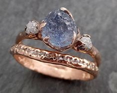 two gold rings with blue and white diamonds on top of each other in front of a black background