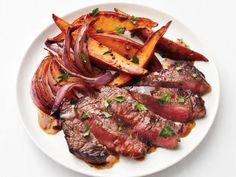 steak, potatoes and onions on a white plate