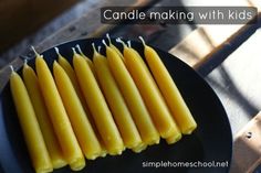 some yellow candles on a black plate with the words candle making with wax in it