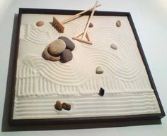 rocks and sticks are arranged on a sand tray