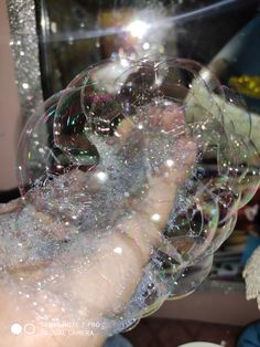 a person is holding soap bubbles in their hand