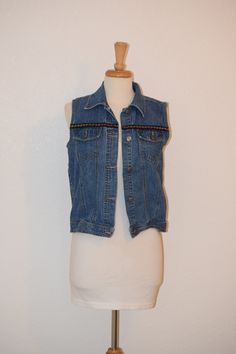 "Retro at its 90's best for popping over your sundress or pairing with your vintage 501 cutoffs. Old school washed / faded denim vest by 'Cherokee' sports hip length styling and fun mini floral embroidered trim.  Laundered and ready to wear.  Free of rips, stains and odor. Women's Small Back of neck to bottom of vest:  23\" Shoulder to shoulder at back:  15\" Under arm seam:  13\" Armpit to armpit:  19\" Side to side at bottom:  19\" For a variety of vintage goodies, check out my shop @: https://www.etsy.com/shop/RagandBonesFinds For a unique pillow fashioned from my treasure trove of vintage fabrics, visit my shop @: https://www.etsy.com/shop/VintagePulledThreads" Festival Vest, Vintage 501, Unique Pillow, Style Vest, 90s Denim, Embroidered Trim, Unique Pillows, Faded Denim, Vest Outfits