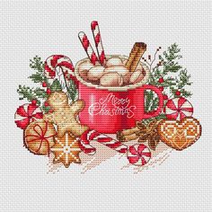 a cross stitch christmas mug filled with hot chocolate and candy canes