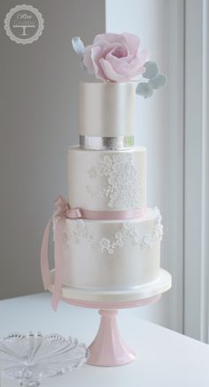 a three tiered wedding cake with pink flowers on top