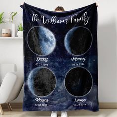 a woman is holding up a blanket with three phases of the moon