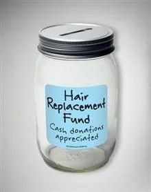 a glass jar with a label stating hair replacement fund cash donations appreciated