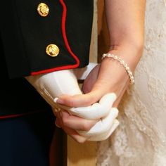 a close up of a person wearing a uniform holding something in their hand with both hands