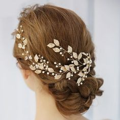 a woman wearing a bridal hair comb with leaves and pearls on it's head