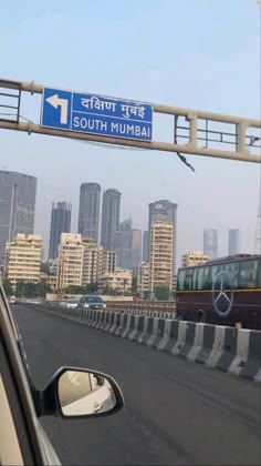 a highway with a sign that says south mumbai on it and buildings in the background