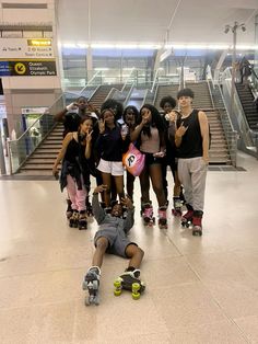 a group of skateboarders pose for a photo in front of an escalator