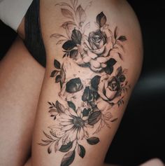 a woman's thigh with a skull and flowers on it