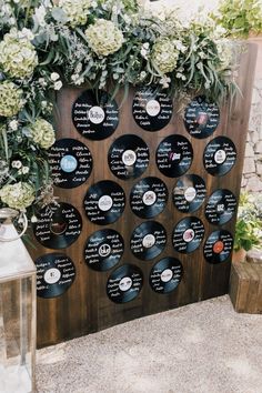 the record wall is decorated with white flowers and greenery for an outdoor wedding ceremony