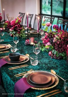 the table is set with purple and green flowers, gold rimmed plates and place settings