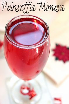 a glass filled with red liquid sitting on top of a table