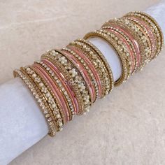 A set of 2 medium sized stacks of sparkling gold and clear stonework bangles on a golden base with pearl details and pretty pink shades. Ready to Ship!  Sold as an option for both arms only. Pink Bangles, Bridal Survival Kit, Bangle Box, Hand Harness, Gold Bangle Set, Bridal Choker, Bangles Set, Bridal Necklace Set, Pearl Details