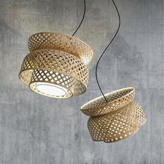 two circular lights hanging from the ceiling in a room with concrete walls and flooring