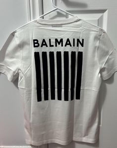 Welcome to my shop where luxury meets affordability! 100% Cotton Material Balmain Limited Edition Quality Tee. Wash Tag Cut from Manufacturer  Check the size Info before placing the order. small chest :- approx 47cm Medium chest :-  approx 51cm Large chest :- approx 54.5cm 2XL chest :- approx 60cm Important: Please Verify Size Measurements Prior to Purchase All Sales Are Final - Your Satisfaction is Our Priority Thank you for shopping with us! We work diligently to provide detailed descriptions Luxury Designer T-shirt With Letter Print, Luxury Men's T-shirt With Exclusive Print, Luxury Tops With Logo Patch For Streetwear, Luxury Letter Print T-shirt, Luxury Tops With Logo, Luxury Logo Top, Luxury Designer T-shirt With Logo Print, Luxury Designer T-shirt With Logo Detail, Luxury Cotton T-shirt With Logo Patch