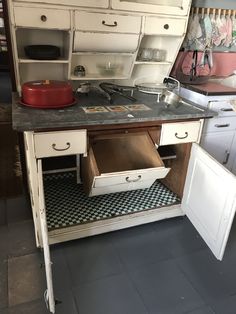 an old fashioned kitchen with white cabinets and drawers