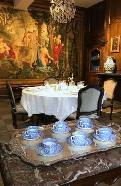 there is a table with blue and white dishes on it in the middle of a room