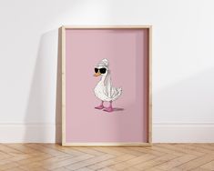 a white duck with sunglasses on its head and in a pink frame against a wall