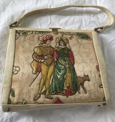 This square quilted medieval scene depicting silk with leather trim bag is from HENRY BIRKS & Sons Limited, a establishment known for their fine watches and jewelry...these bags were sold in their stores as well, although, not manufactured by them. The tag in this bag, photo 8, shows the Henry Birks & Sons logo, which is a lion, and an explanation that the bag was made for the Birks company. The bag was made in England, and as far as date of manufacture, there was a letter in the bag, written in May 1960, and a used theater ticket stub dated April of 1960. So the bag is clearly older than the year 1960... The bag is square in shape, and has a short single strap. It is made of 1. leather, which trims the strap, sides and bottom. There  is:  2. brass hardware that anchor the strap, 2 brass a Vintage Quilted Shoulder Bag For Formal Occasions, Formal Vintage Quilted Shoulder Bag, Vintage Quilted Leather Bag, Vintage Quilted Leather Shoulder Bag, Vintage Quilted Shoulder Bag, Vintage Embroidered Leather Bags, Vintage Square Bags, Medieval Couple, Medieval Maiden