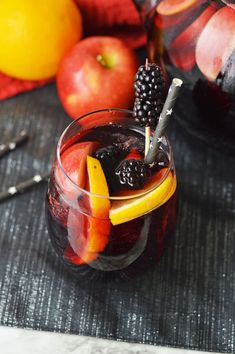 a glass filled with liquid and fruit on top of a table