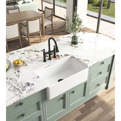 a kitchen sink sitting on top of a counter next to a dining room table and chairs