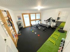 an indoor gym with treadmills, exercise equipment and ladders to the ceiling