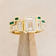 Product Details Ring Style: The Greta" is an art deco-style bezel set moissanite women's engagement ring with moissanite accent stones and a malachite stacking band. Many other center stone options are available upon request. Center Stone: 8x6mm Emerald Cut Moissanite Materials: 14K white gold engagement ring featuring 3 main moissanite stones, baguette moissanite side stones, and a malachite inlay tracer. Customizable: Because each ring is handcrafted to order, we can customize yours using unique materials, gemstones, or design features, often without any added cost! We can even use personal materials that you send! Basic customizations, such as material swaps, can be accommodated by simply adding a request in the “Custom Requests” section during checkout. For more extensive customization Unique Bezel Set Engagement Ring, Art Deco Emerald Engagement Ring, Wedding Band For Emerald Cut Ring, Brand Identity Jewelry, Non Traditional Wedding Ring, Emerald Cut Moissanite Engagement Ring, Emerald Wedding Band, Bezel Set Engagement Ring, Art Deco Wedding Band