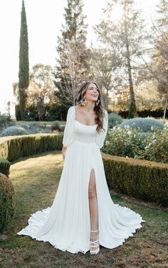 a woman in a white dress is standing on the grass with her legs spread out