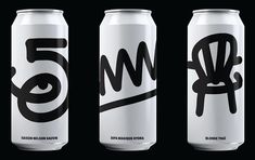 three cans of soda with black and white designs