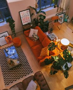 an overhead view of a living room with orange couches and rugs on the floor