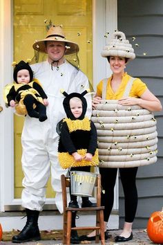 a man and woman in bee costumes with two children